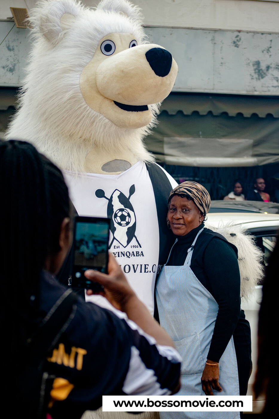 The Bosso Movie mascot taking a photo with a community member